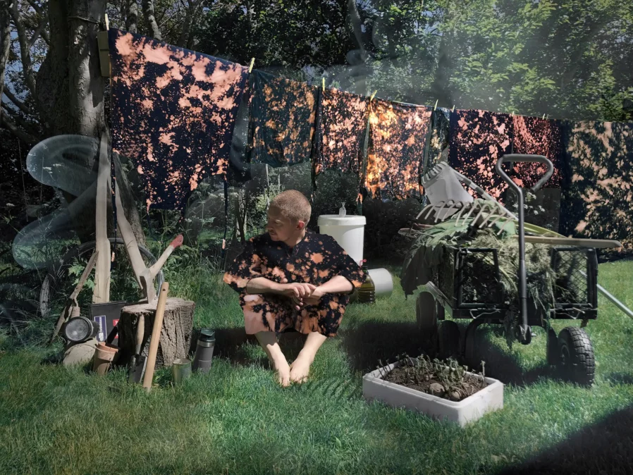 A man sitting on the ground in a garden like setting